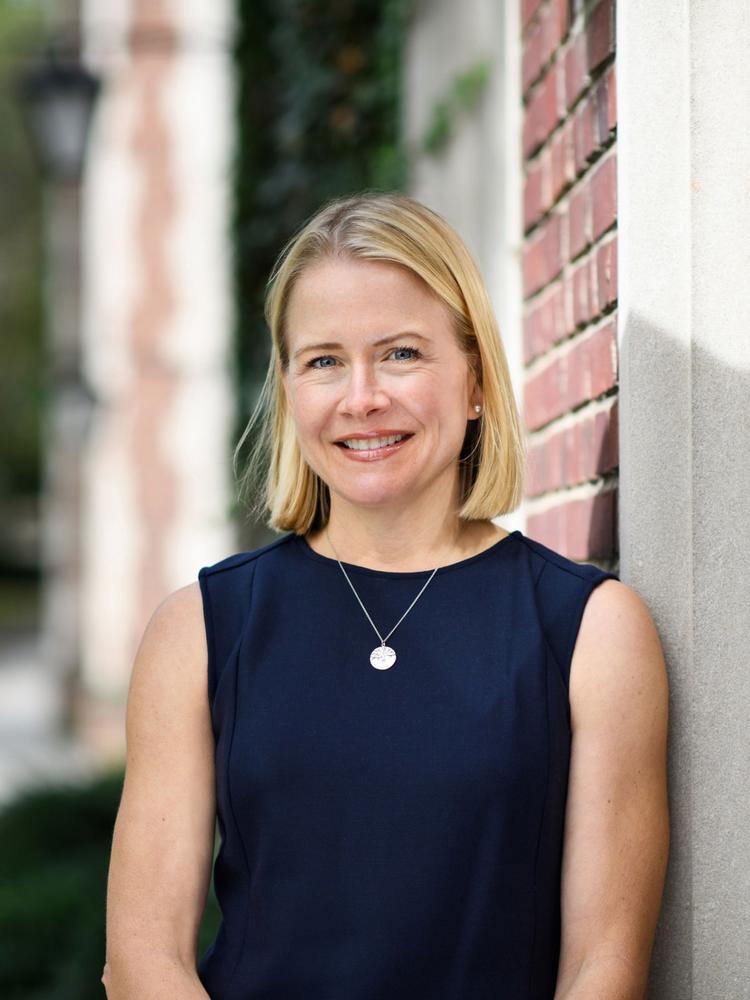 Sarah McGrath standing by a brick building.