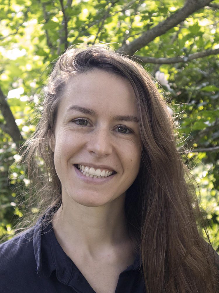 Caitlin Blanchfield standing in front of trees.