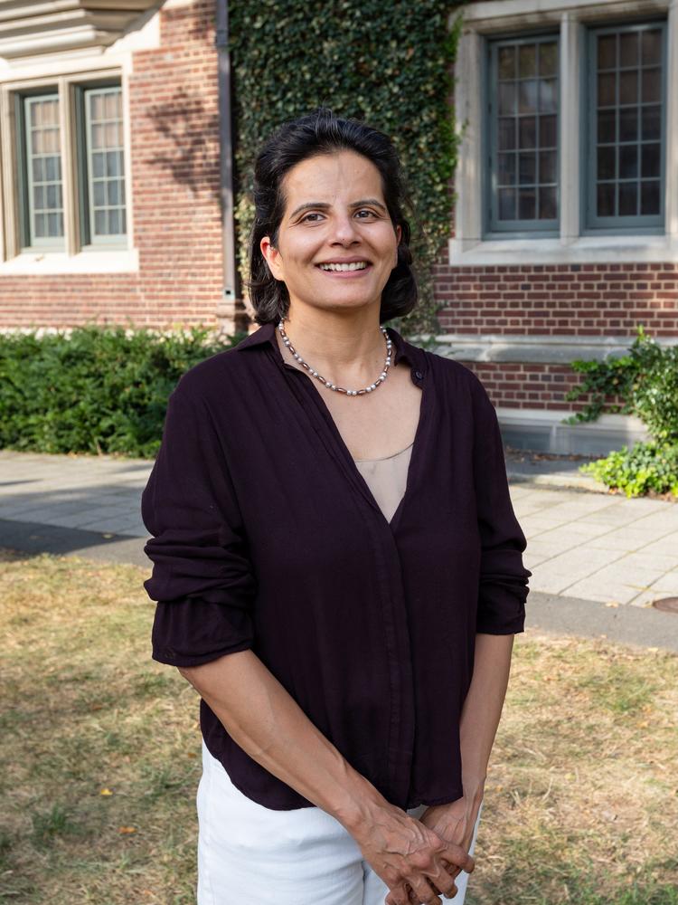 Tehseen Thaver standing in front of a brick building.